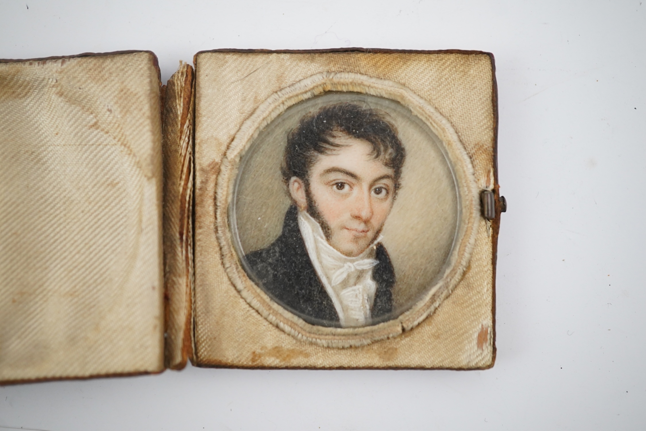 A mid 19th century French portrait miniature of a gentleman on ivory, in leather case inscribed 'Souvenir', 4.3cm high overall. CITES Submission reference V6R44LRJ. Condition - fair to good.